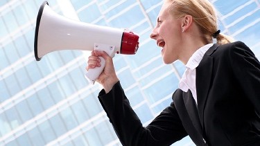 Frau mit Megaphone erhebt Ihre Stimme - AK fordert verbindliche Geschlechterquote in Aufsichtsräten!