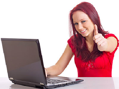 Junge freie Dienstnehmerin arbeitet am Laptop
